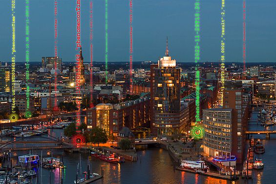 Skyline der Hamburger Speicherstadt bei Nacht. Im Vordergrund symbolisieren Zahlenreihen das Thema Digitalisierung.